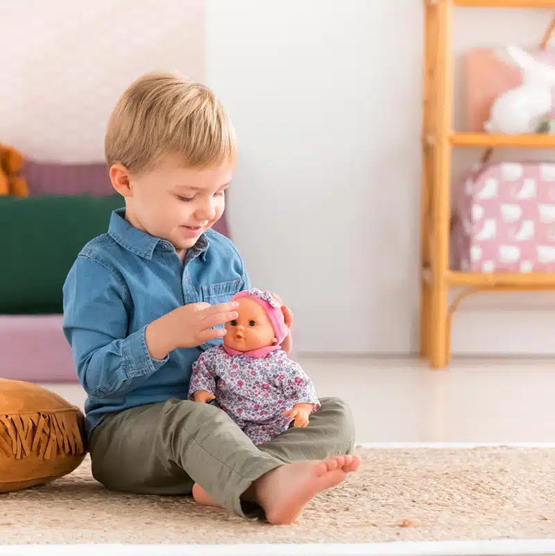 enfant jouant avec un poupon corolle