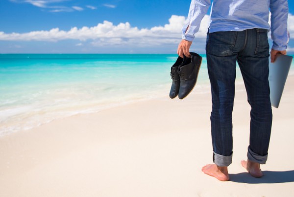 Young man with laptop during tropical beach vacation